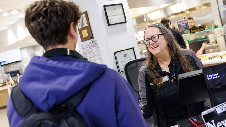 Claudia Wheeler helping a student in the dining hall